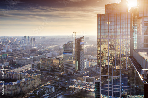 view from the roof of a skyscraper to sunset and other skyscrapers in Moscow / facade of a skyscraper with reflection in the glass