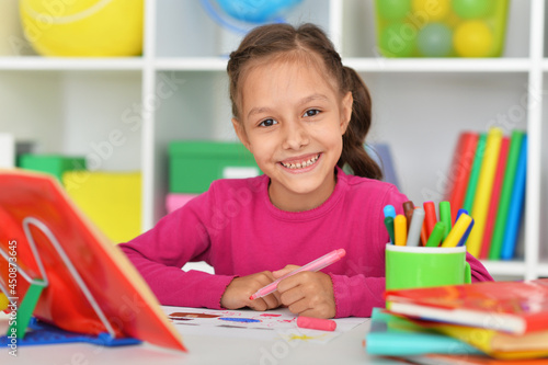 Close up portrait of cute smiling girl drawing