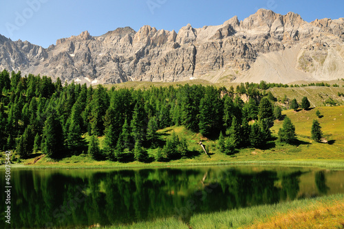 Lac miroir et forêt de pins au-dessus du village de Ceillac, Parc naturel régional du Queyras, Alpes du Sud, France. photo