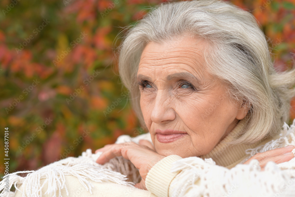 Close up portrait of sad senior woman in autumn park Close up portrait of sad senior woman in autumn park