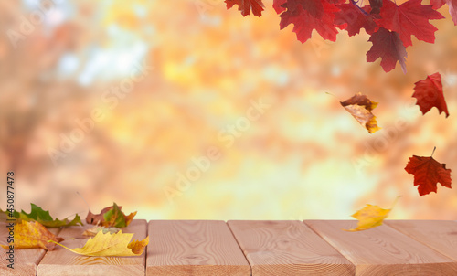 maple leaves on the wood floor in the autumn background with copy space 