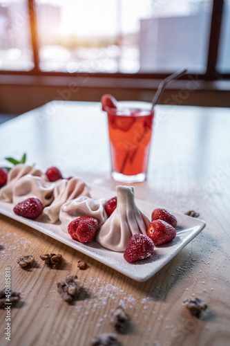 sweet dumplings or khinkali with strawberry and cold red lemonade drink on table