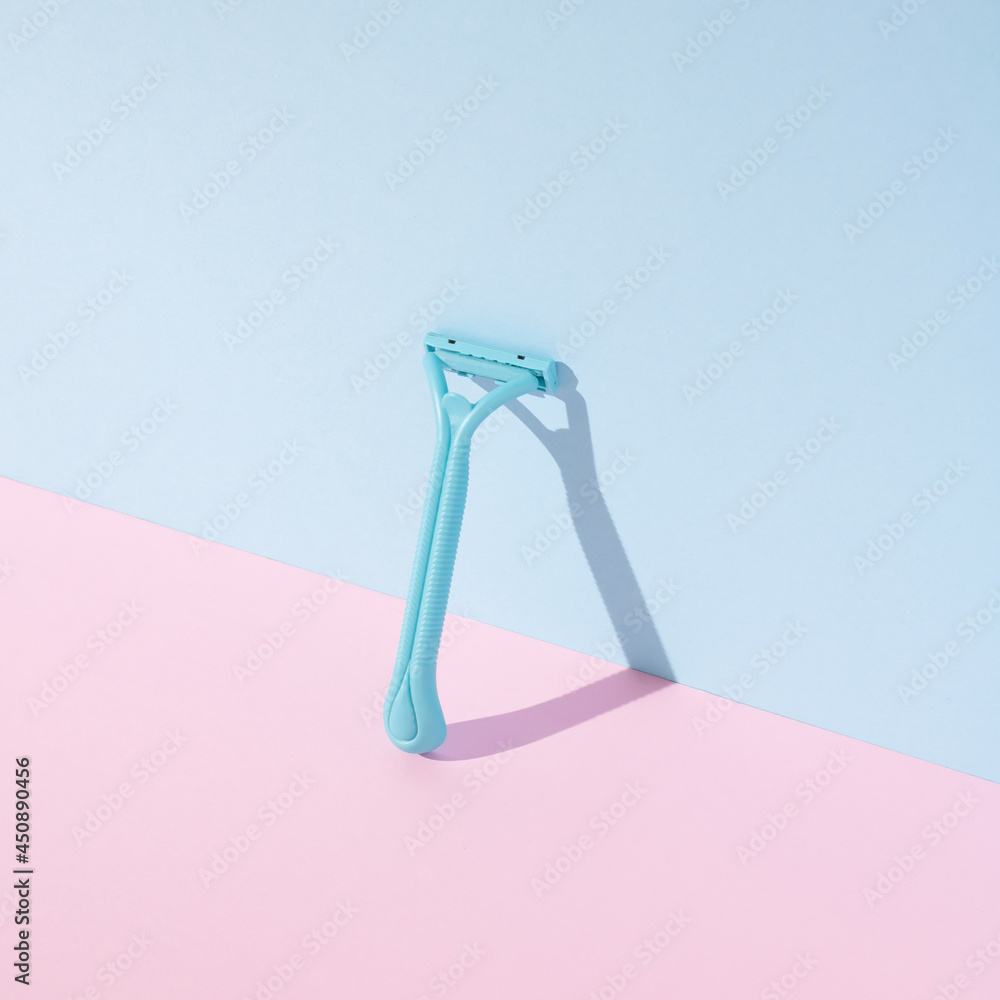 Plastic beard razor with shadow on pastel pink and blue background ...