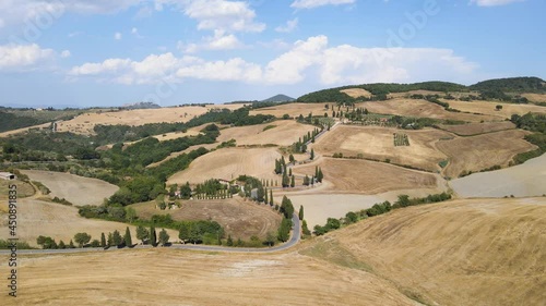Flight over the road in Tuscany with farm houses and fields, Italy