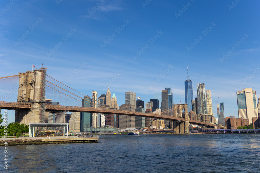 Cityscape of Brooklyn Bridge and Lower Manhattan skyscraper from beach of Brooklyn Bridge Park on June 18, 2021 in Brooklyn New York City.