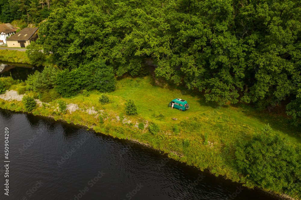 Aerial view of river Vltava with vanlife car on free grass place. Perfect place for camping in wildlife.