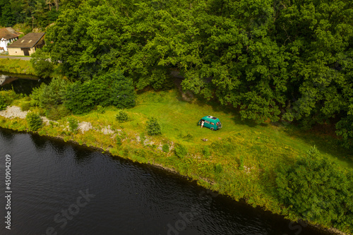 Aerial view of river Vltava with vanlife car on free grass place. Perfect place for camping in wildlife.