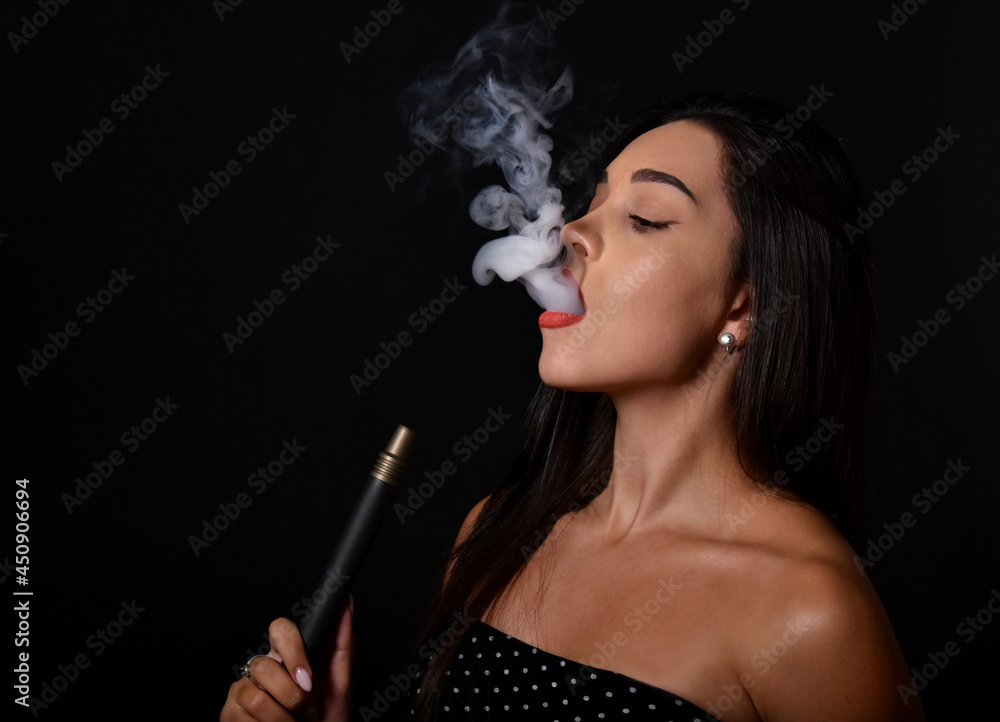 Obraz premium Beautiful and sexy girl smokes hookah, sheesha. Sexy woman smoking. The pleasure of smoking. 