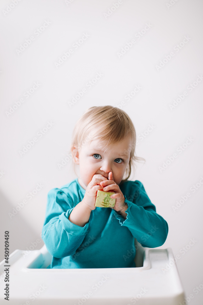 portrait of a funny little baby girl sitting in a high chair and eating watermelon portrait of a funny little baby girl sitting in a high chair and eating watermelon