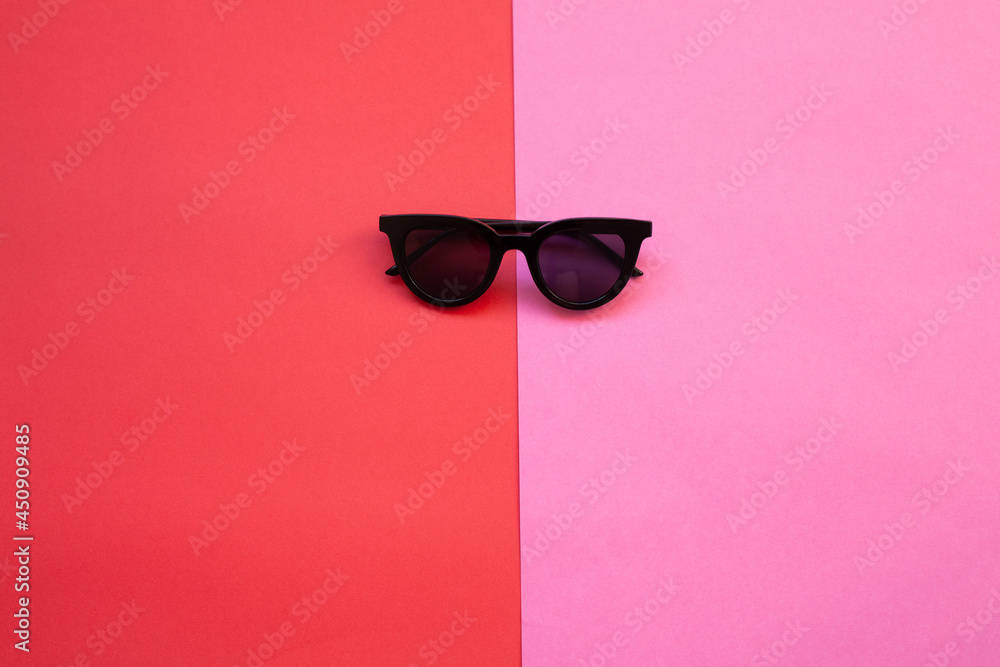 Beautiful trendy sunglasses isolated on pink and red Beautiful trendy sunglasses isolated on pink and red