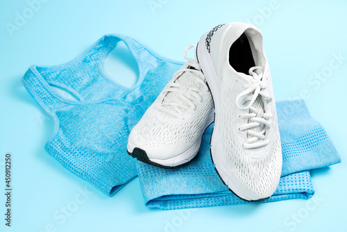 Fitness sport white sneakers and blue tracksuit on a blue background.
