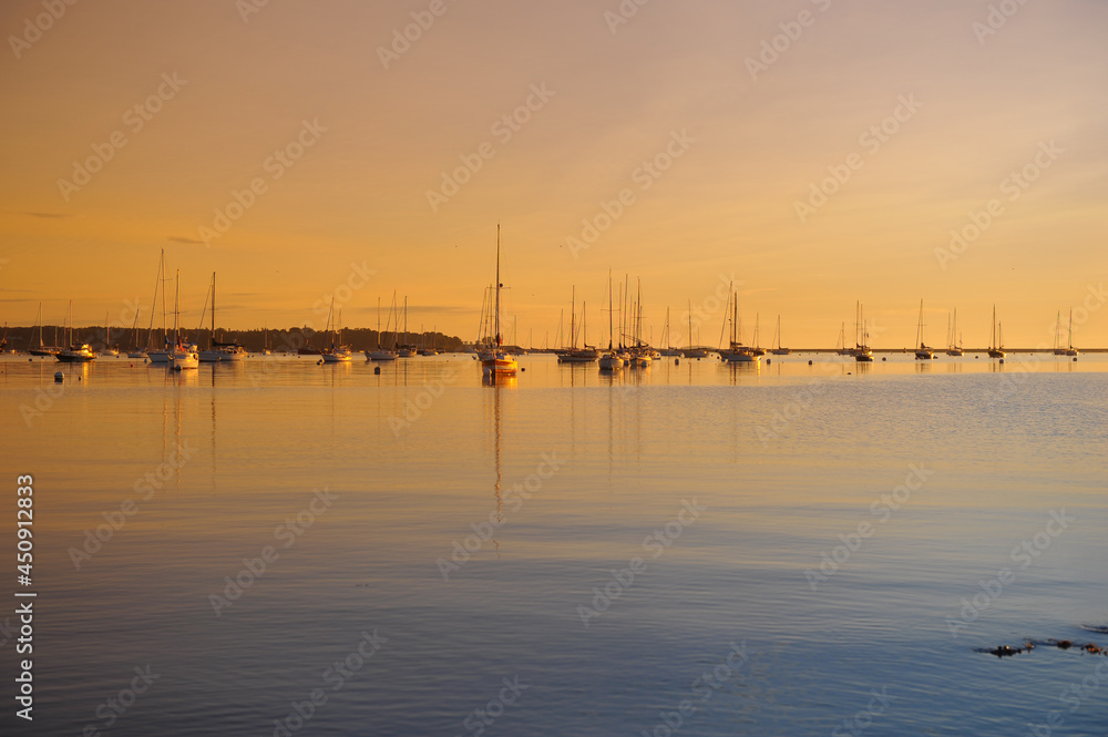 Sunrise and sailboats on calm waters in Maine Sunrise and sailboats on calm waters in Maine