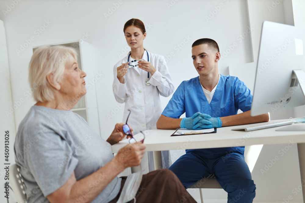 elderly woman patient at doctor's appointment and nurse in office elderly woman patient at doctor's appointment and nurse in office
