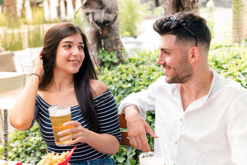 Attractive young woman flirting with a man over beers photo