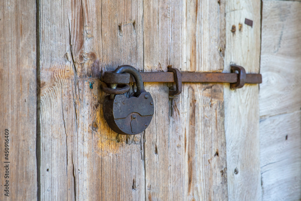 Old metallic padlock on a wooden door Old metallic padlock on a wooden door