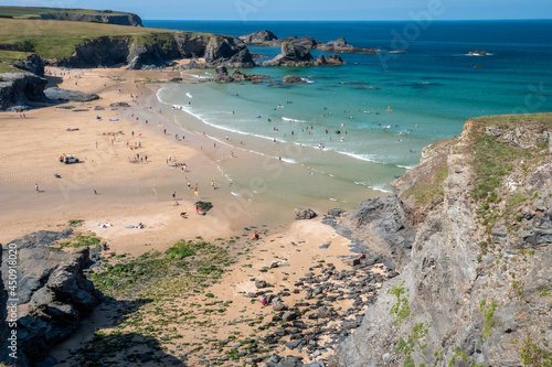 Looking down from the cliffs at the beach at Cornwall s Porthcothan bay on beautiful summer s day