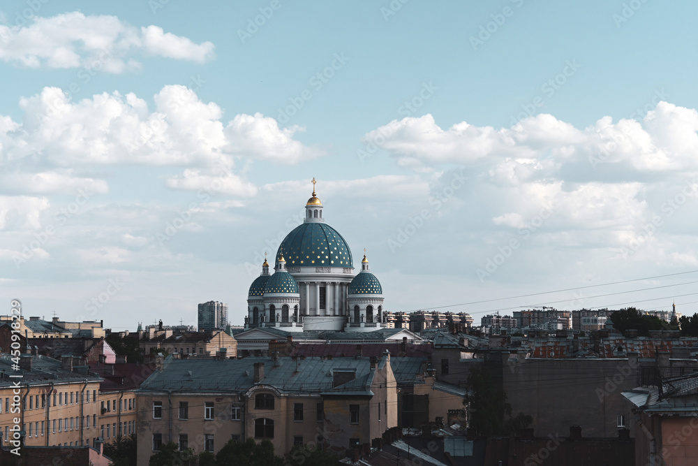 The Trinity-Izmailovsky Cathedral is an Orthodox cathedral in the central part of the old city against the background of a blue sky with white clouds. The architecture of the old center of St. Petersb