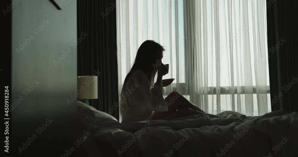 Thoughtful girl enjoying cup of coffee in cozy bed. Pensive asian woman thinking about plans, starting new day - fresh start, new beginnings 4k footage Thoughtful girl enjoying cup of coffee in cozy bed. Pensive asian woman thinking about plans, starting new day - fresh start, new beginnings 4k footage