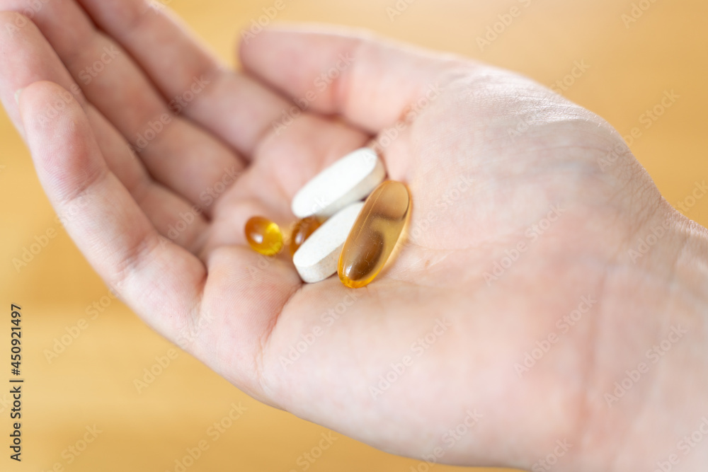 Close up of hand with pills on it. Supplements with omega, vitamin d, magnesium. Medications for disease treatment