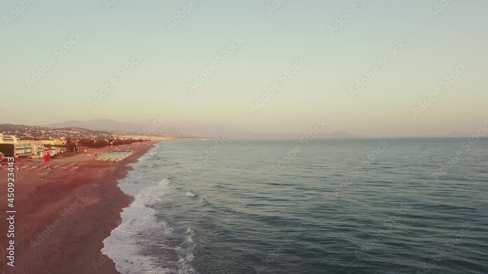 A drone flies along the beach of the Aegean Sea on the island at sunrise. A drone flies along the beach of the Aegean Sea on the island at sunrise.