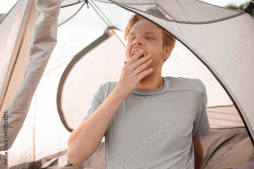 A ginger man sitting in the tent and feeeling sleepy photo