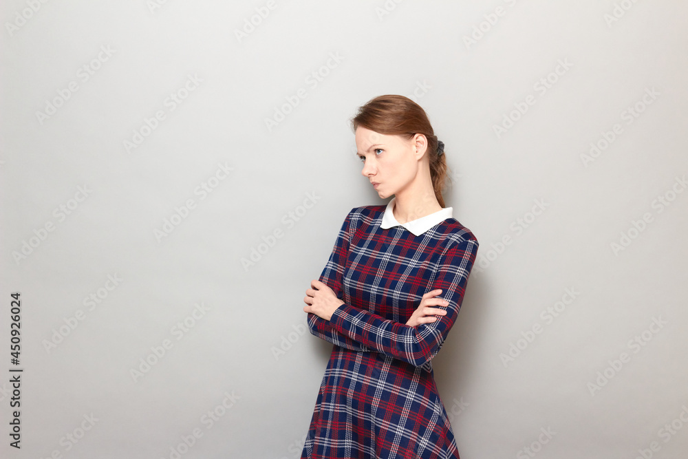 Portrait of serious blond young woman holding arms folded Portrait of serious blond young woman holding arms folded