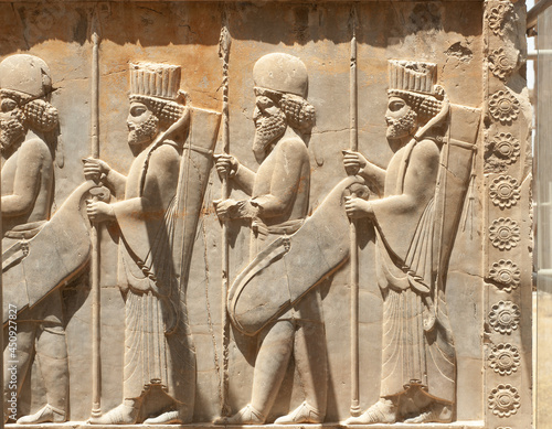 Soldiers of historical empire with weapon in hands. Stone bas-relief in ancient city Persepolis, Iran. Capital of the Achaemenid Empire (550 - 330 BC). UNESCO declared Persepolis a World Heritage Site photo