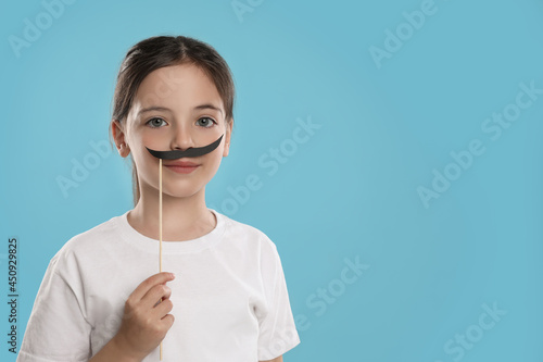 Cute little girl with fake mustache on turquoise background, space for text