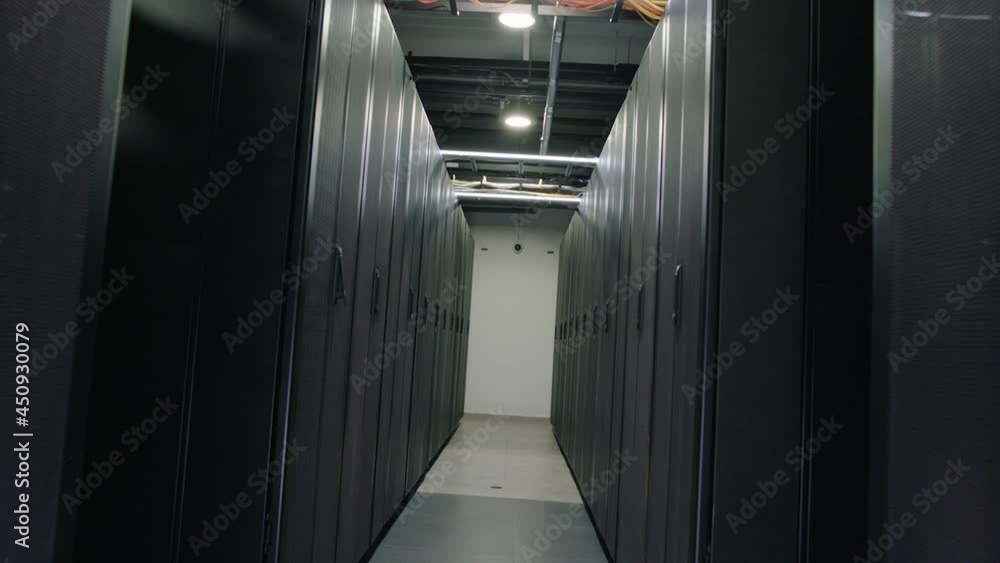Camera moves through big working data center with server racks . Real shot of high tech server room with metallic doors . Inside telecom server room. Shot on ARRI ALEXA Cinema Camera with gimbal move Camera moves through big working data center with server racks . Real shot of high tech server room with metallic doors . Inside telecom server room. Shot on ARRI ALEXA Cinema Camera with gimbal move