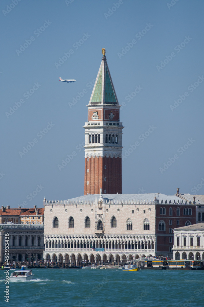 Campanile di San Marco and Doge's Palace, in Venice, Italy, 2019 and a passenger plane passing by the tower