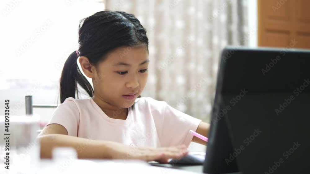 asian little girl communicates with a teacher via the Internet. Online training during quarantine. asian little girl communicates with a teacher via the Internet. Online training during quarantine.