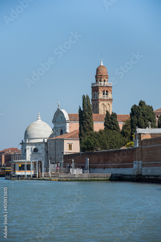 An old church with bell tower and domes on canal in Venice, Italy, 2019