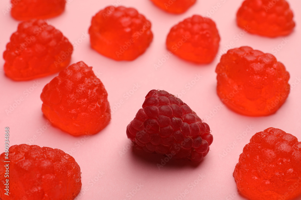 Delicious gummy candies and fresh raspberry on pink background, closeup Delicious gummy candies and fresh raspberry on pink background, closeup