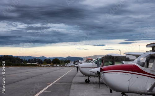 Airplanes parked at the Airport Apron during a dramatic cloudy sunset. Pitt Meadows, Greater Vancouver, British Columbia, Canada.