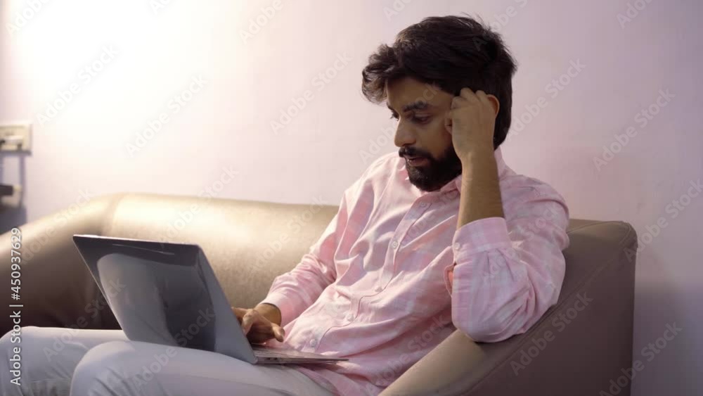 The boy is working on the laptop and he is working under a lot of tention. The boy is working on the laptop and he is working under a lot of tention.