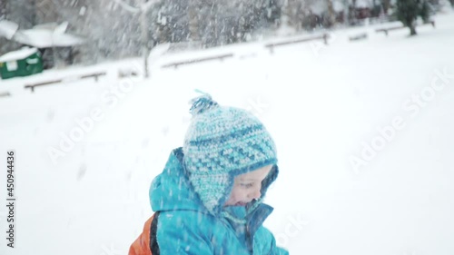 Boy plays and throws snow in the air on a winter day