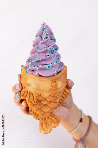 Mano de mujer agarrando helado estilo japonés  en fondo blanco