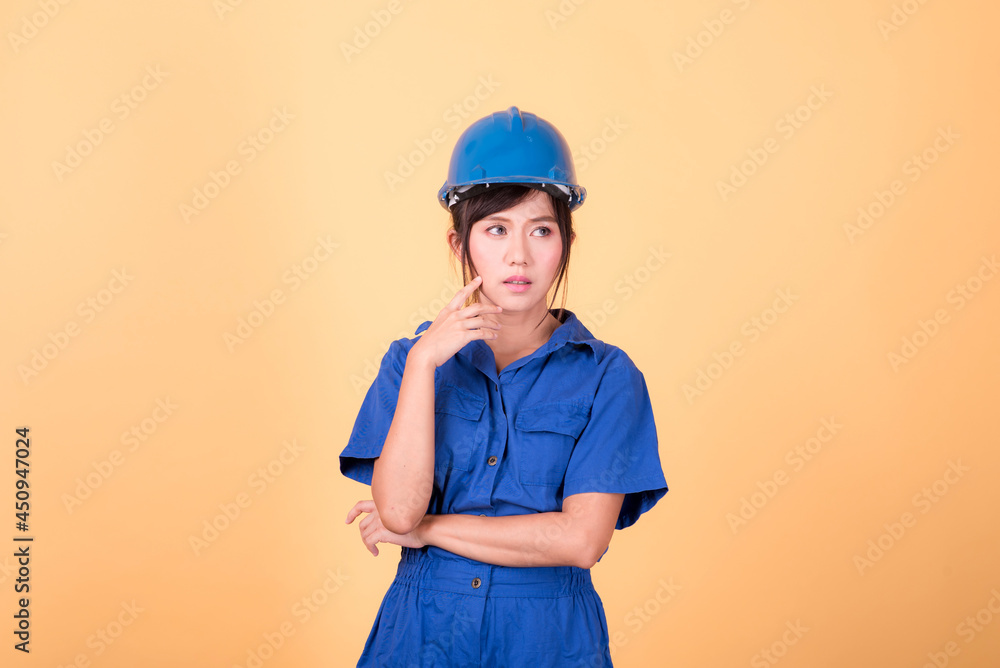 Portrait woman mechanic checking on yellow background Portrait woman mechanic checking on yellow background