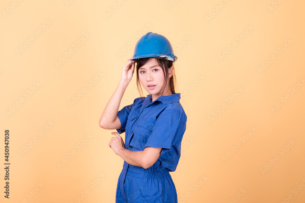 Portrait woman mechanic checking on yellow background Portrait woman mechanic checking on yellow background