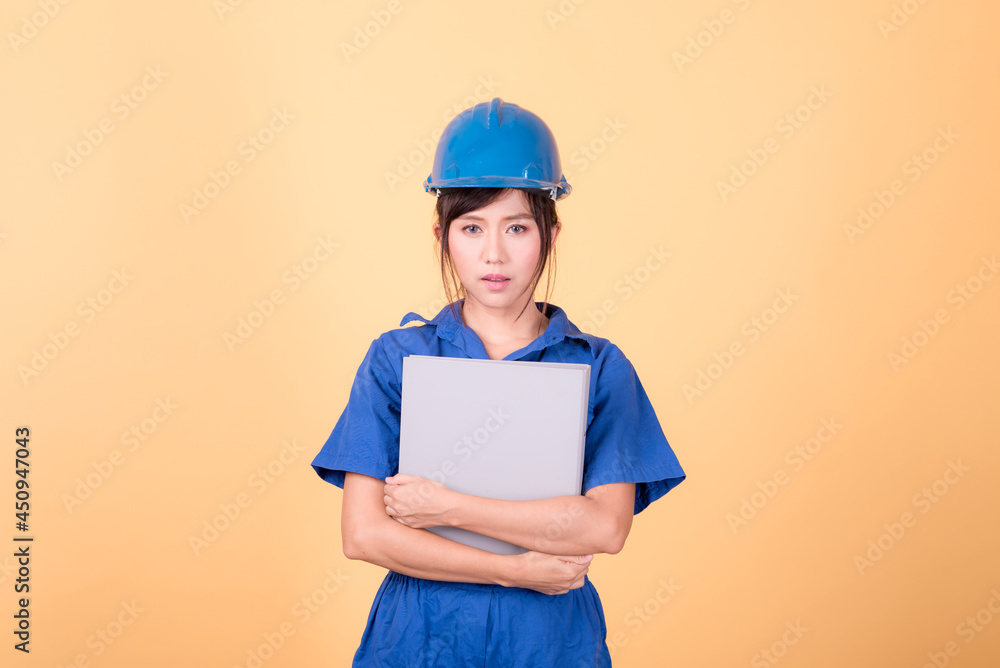 Young Asian female engineer working deliberately isolated on yellow background. Young Asian female engineer working deliberately isolated on yellow background.