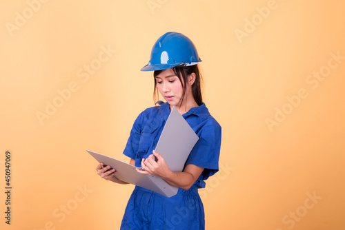 Young Asian female engineer working deliberately isolated on yellow background.	