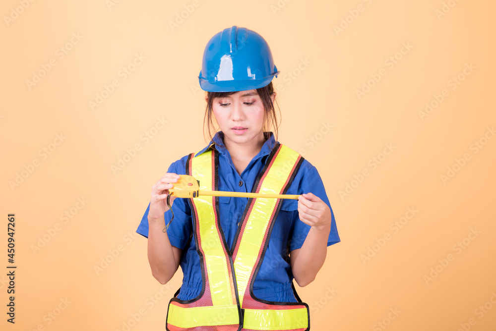 Portrait woman mechanic checking on yellow background Portrait woman mechanic checking on yellow background