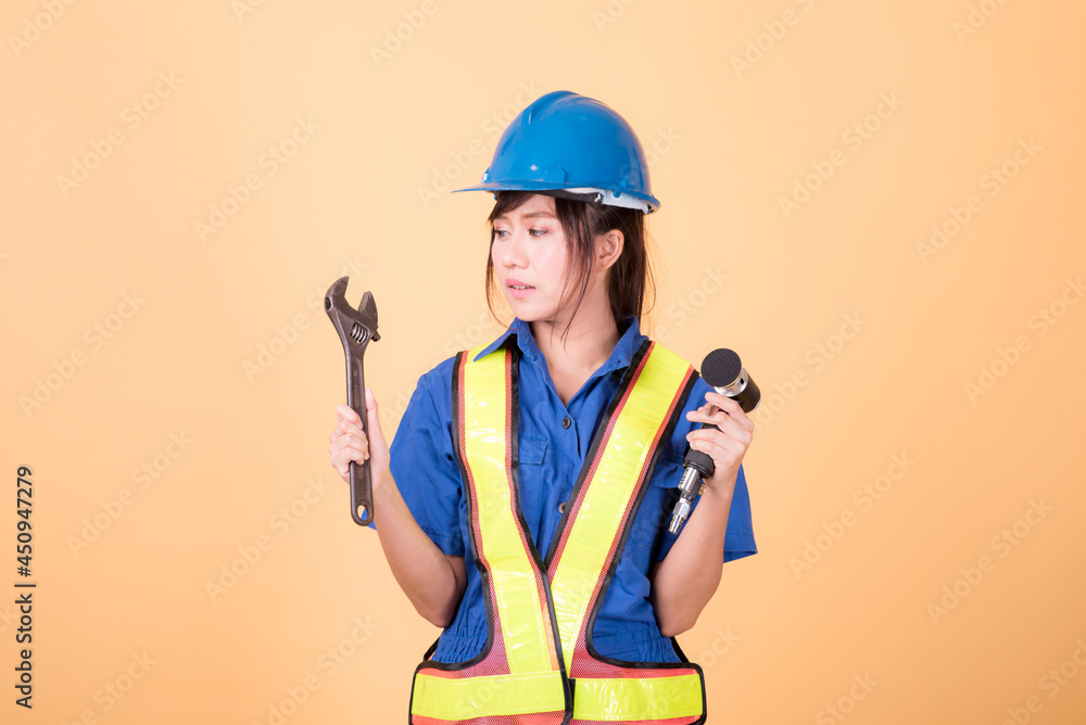 Portrait woman mechanic checking on yellow background Portrait woman mechanic checking on yellow background