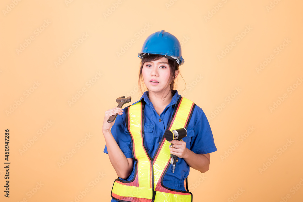 Portrait woman mechanic checking on yellow background Portrait woman mechanic checking on yellow background