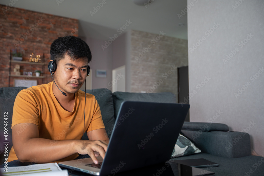 Asian businessmen is using notebook computers and wear headphones for online meetings and working from home. Asian businessmen is using notebook computers and wear headphones for online meetings and working from home.
