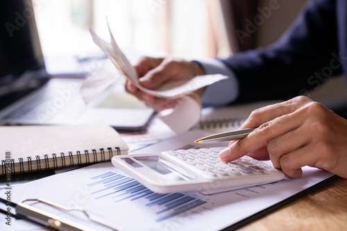Close-up of a businesswoman using a white calculator, a financial businessman examining the numerical data on a company financial document, Accountant Calculating Electronic Invoice Or E Bill