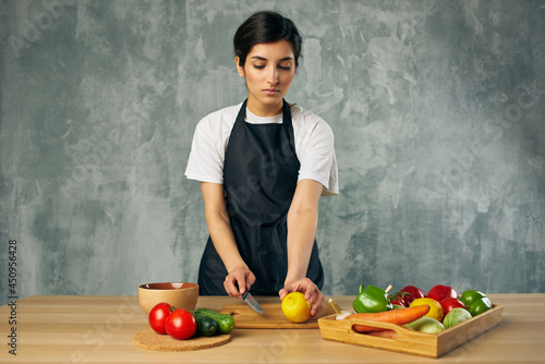 housewife on the kitchen cutting vegetables isolated background