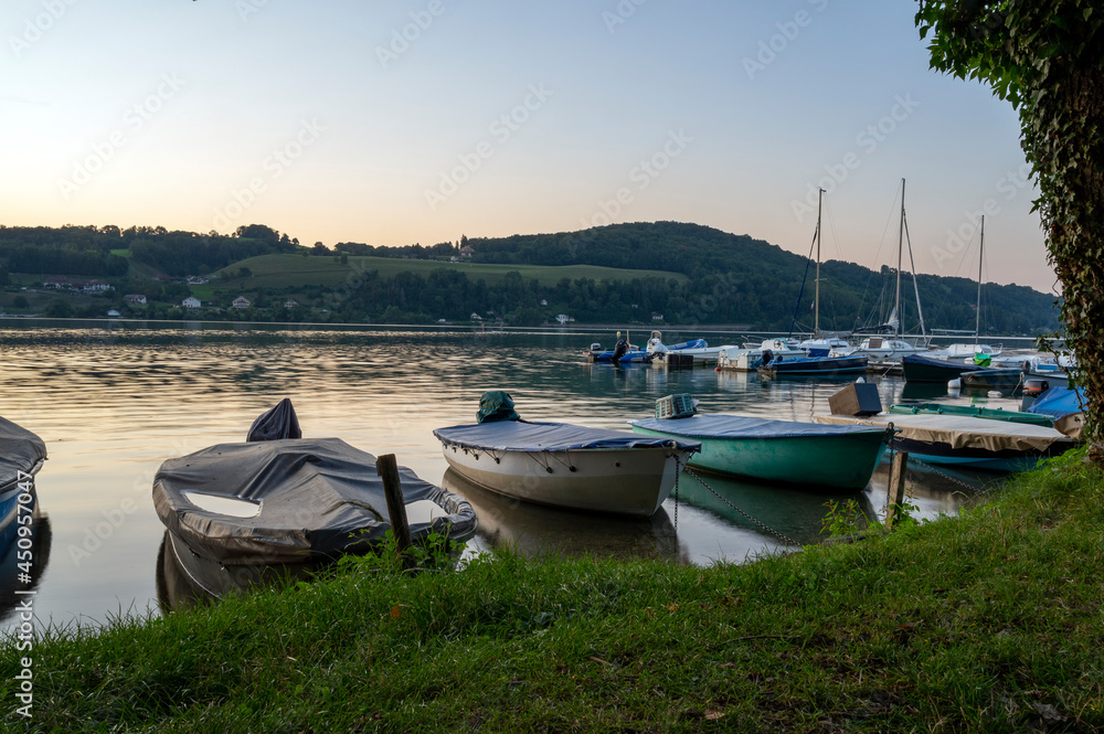 Coucher de soleil sur le lac de Paladru en france en Isère en été avec des bateaux en premier plan