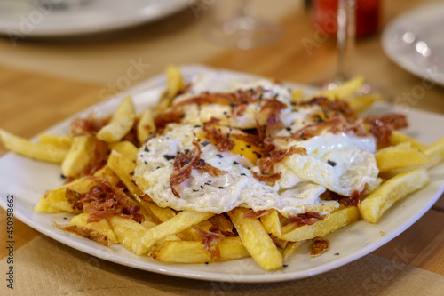 Typical Spanish food, fried eggs, chips and ham. Scrambled eggs