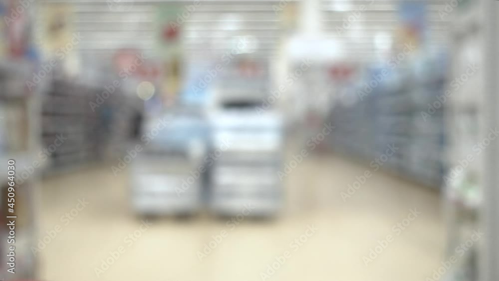 Rows in the supermarket. Blurred people walking in supermarket with shopping cart. Rows in the supermarket. Blurred people walking in supermarket with shopping cart.